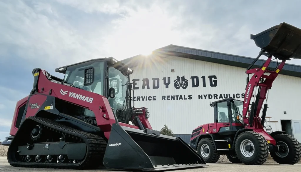Yanmar TL100VS track loader and V10 wheel loader parked at ReadyDig dealership highlighting durable compact equipment.